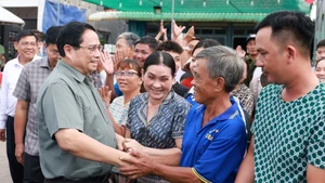 El primer ministro Pham Minh Chinh visita a los habitantes de la comuna de Binh My, provincia de An Giang. (Foto: VNA)