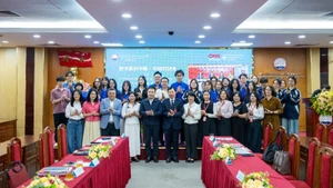Los delegados y estudiantes de la Academia de Periodismo y Comunicación se toman una foto de recuerdo. (Foto: Hoang Lan)