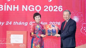 La directora general de la VNA, Vu Viet Trang, obsequia al secretario general To Lam un libro fotográfico realizado por reporteros de la agencia. (Foto: VNA)