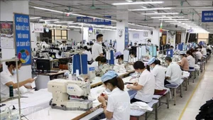 Trabajadores de una fábrica textil que exporta productos en Garco 10 en Hanói. (Foto: VNA)