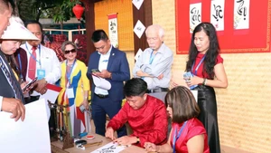 Vietnamitas en el extranjero hacen fila para pedir caligrafía. (Fuente: VNA)