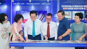 Nguyen Trong Nghia (tercero desde izquierda), miembro del Buró Político, secretario del Comité Central del Partido Comunista de Vietnam y jefe de su Comisión de Información, Educación y Movilización de Masas, visita el stand de la Agencia vietnamita de Noticias (Fuente: VNA)