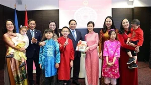 El primer ministro Pham Minh Chinh y su esposa otorgan libros en idioma vietnamita a la comunidad de residentes vietnamitas en Estonia. (Foto: VNA) 