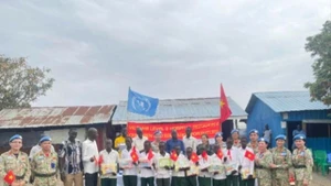 El grupo de trabajo del Hospital de Campaña de segundo nivel número 6 de Vietnam entrega obsequios a alumnos de la Escuela Primaria Banpa, Sudán del Sur. 