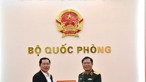 El jefe del Estado Mayor General del Ejército Popular de Vietnam y viceministro de Defensa, general Nguyen Tan Cuong (derecha), entrega un obsequio al coronel general Saichay Kommasith, viceministro de Defensa y jefe del Estado Mayor General del Ejército Popular de Laos. (Foto: qdnd.vn)