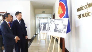 El secretario del Comité Central de la Unión de Jóvenes Revolucionarios del Pueblo de Laos, Thongly Sisoulith, visita la exposición fotográfica instalada en el evento sobre las relaciones especiales entre Vietnam y Laos. (Foto: VNA)