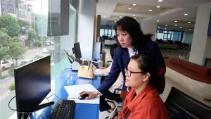 Funcionarios del Centro de Servicios Administrativos Públicos de Hanói gestionan trámites administrativos para los ciudadanos. (Foto: VNA)