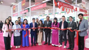 El consejero comercial Bui Trung Thuong (cuarto desde la izquierda) de la Embajada de Vietnam en la India y Rakesh Kumar (quinto desde la derecha), presidente del Centro de Exposiciones de la India, cortan la cinta inaugural del stand vietnamita. (Foto: VNA)