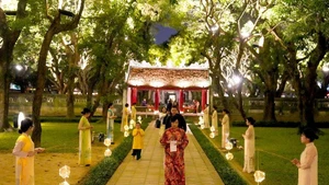 Turistas disfrutan del recorrido nocturno "Sonidos de Vietnam" en el Templo de la Literatura. (Foto: hanoimoi.vn)