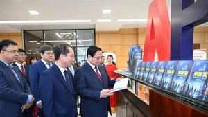El primer ministro Pham Minh Chinh y delegados visitan el área expositiva sobre los libros y las actividades de la academia.