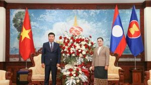 El miembro del Comité Central del Partido Comunista de Vietnam y viceministro de Relaciones Exteriores, Nguyen Manh Cuong, y la embajadora de Laos en Vietnam, Khamphao Ernthavanh, en la reunión. (Foto: baoquocte.vn)