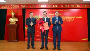 Le Quoc Minh (centro), miembro del Comité Central del Partido Comunista de Vietnam y del Buró Ejecutivo del Comité del Partido del Frente de la Patria y las asociaciones de masas centrales, presidente-editor del periódico Nhan Dan y titular de la Asociación de Periodistas de Vietnam, recibe la decisión de nombramiento. (Foto: Nhan Dan)