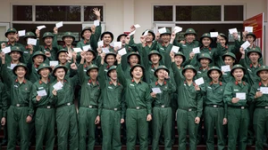 Los nuevos reclutas del Pelotón 14 de la Compañía 15 (Batallón 4, Brigada 144, Estado Mayor General del Ejército Popular de Vietnam), regocijados al sostener sus papeletas de votación para las próximas elecciones generales.