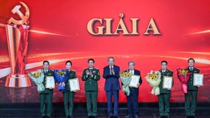 El secretario general del Partido Comunista de Vietnam, To Lam (centro), y el general Phan Van Giang, ministro de Defensa, entregan el premio A a los autores ganadores. (Foto: Nhan Dan)