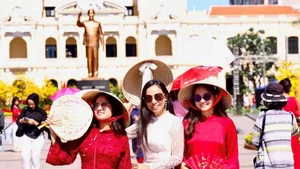 Vietnamitas que regresan del exterior exploran la calle de flores de Nguyen Hue. (Foto: qdnd.vn)