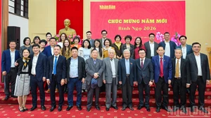 Dirigentes y exdirigentes de Nhan Dan se toman fotos junto con empleados del periódico en ocasión del Año Nuevo Lunar.