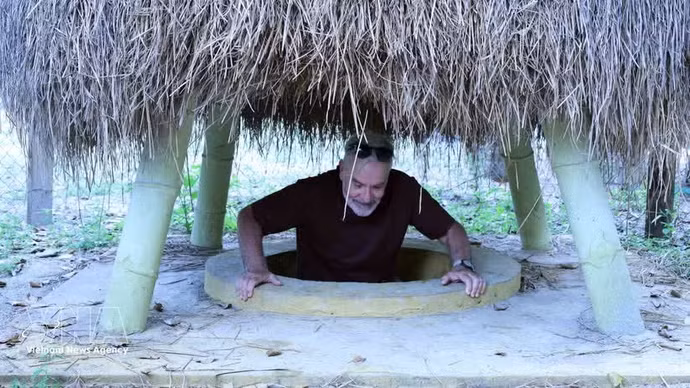 El turista se sitúa en una entrada de túnel ubicada en el jardín de una vivienda en el túnel de Ky Anh. (Foto: VNA)