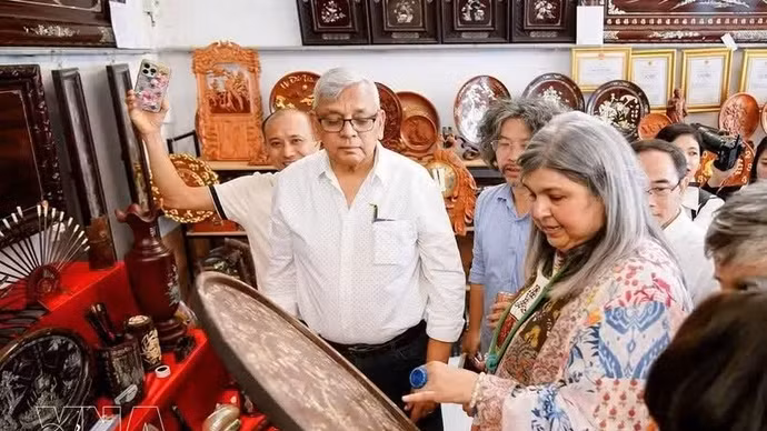 Turistas descubren y experimentan los productos artesanales elaborados en la aldea de incrustaciones de nácar de Chuyen My. (Foto: VNA)