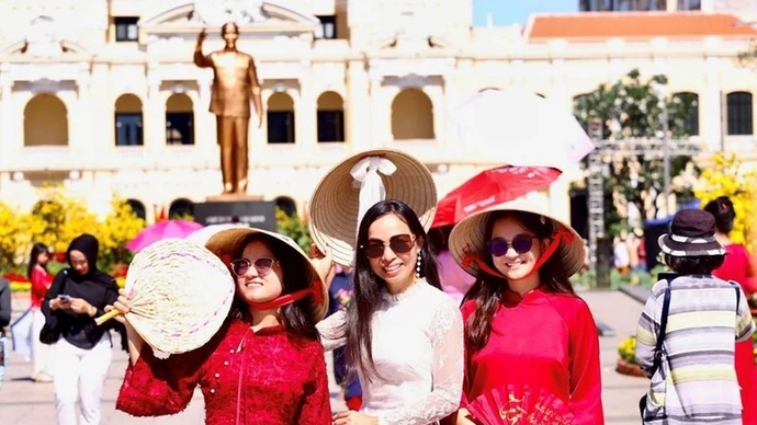 Vietnamitas que regresan del exterior exploran la calle de flores de Nguyen Hue. (Foto: qdnd.vn)