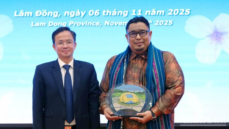 El director del Servicio de Cultura, Deporte y Turismo de Lam Dong, Nguyen Van Loc, entrega un obsequio a la delegación de trabajo de Malasia, encabezada por Fathir Badri Alhadad, presidente de la Asociación de Turismo y Viajes de ese país.