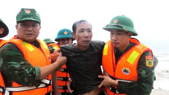 Guardias fronterizos rescatan a un hombre de un barco hundido el 12 de noviembre de 2025 en el estuario de Nhat Le. (Foto: VNA)