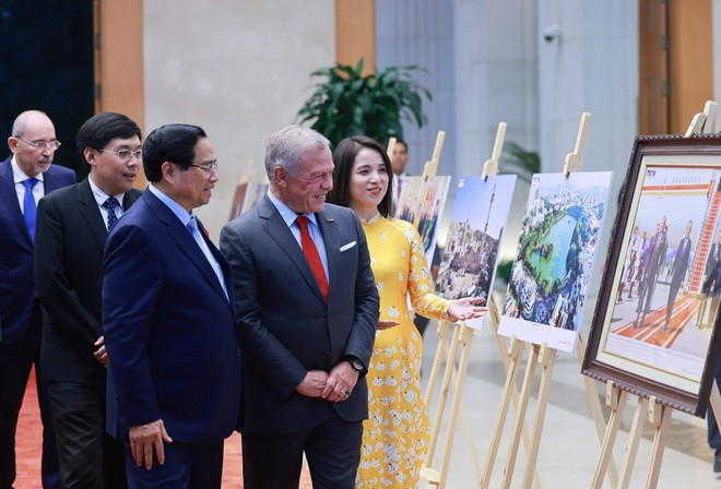 El primer ministro Pham Minh Chinh y el rey Abdalá II Ibn Al Hussein de Jordania visitan una exposición fotográfica sobre la cooperación bilateral, organizada por la Agencia Vietnamita de Noticias. (Foto: VNA)