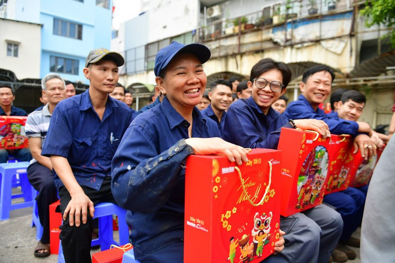 La felicidad se trasluce en el rostro de Nguyen Thi Hang, que lleva 30 años trabajando en la Sucursal de Vagones de Saigón, al recibir el apoyo de las entidades colaboradoras del programa «Construir Tet 2026». (Foto: The Anh).