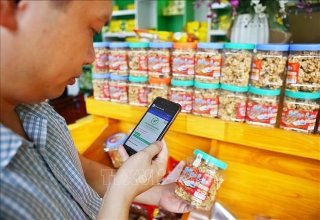 Los usuarios pueden escanear el código QR con sus teléfonos inteligentes para rastrear el origen del producto. (Foto: VNA)