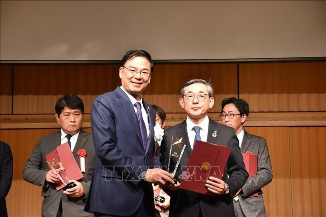 El embajador de Vietnam en Japón, Pham Quang Hieu, entrega una carta de reconocimiento y una copa conmemorativa al director de la empresa Corps, Kato Ryo. (Foto: VNA)