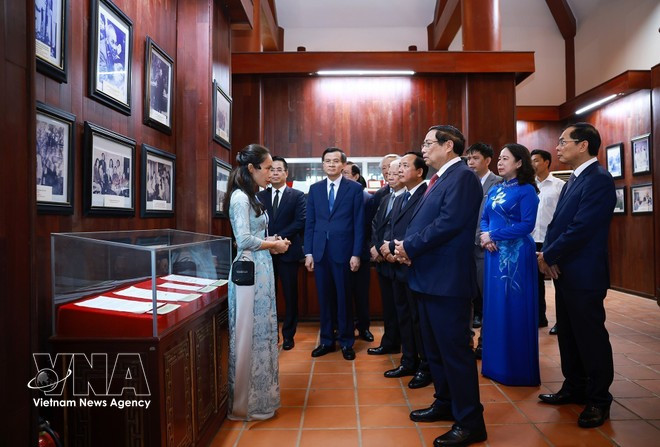 El primer ministro Pham Minh Chinh recorre la exposición de imágenes y objetos históricos sobre Pham Van Dong en su Área Conmemorativa en la comuna de Mo Duc, provincia de Quang Ngai. (Foto: VNA)