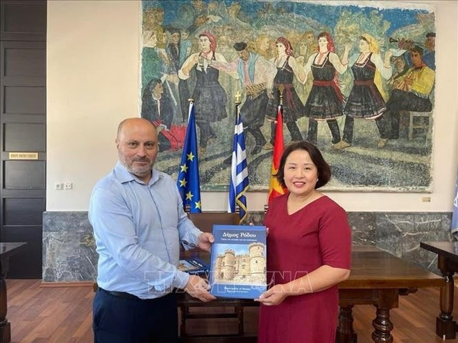 El vicealcalde de Rodas, responsable de economía, finanzas y patrimonio cultural, Chalkias Konstantinos, entregó un libro a la embajadora de Vietnam en Grecia, Pham Thi Thu Huong. (Fuente: VNA) El vicealcalde de Rodas, responsable de economía, finanzas y patrimonio cultural, Chalkias Konstantinos, entregó un libro a la embajadora de Vietnam en Grecia, Pham Thi Thu Huong. (Fuente: VNA)