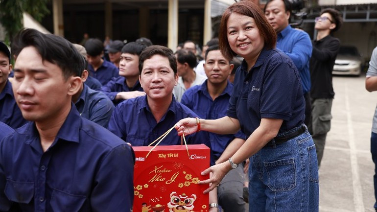 La directora de Relaciones Exteriores de la Empresa Conjunta de Construcción Coteccons, Dinh Thi Hong Tham, entrega regalos a trabajadores de la Sucursal de Vagones de Saigón. (Foto: The Anh)