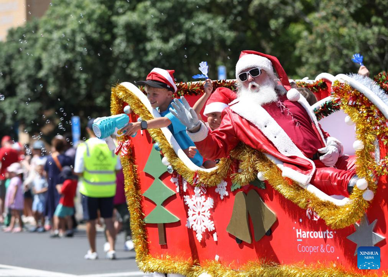 Un hombre vestido de Papá Noel participa en un desfile navideño en Auckland (Nueva Zelanda).