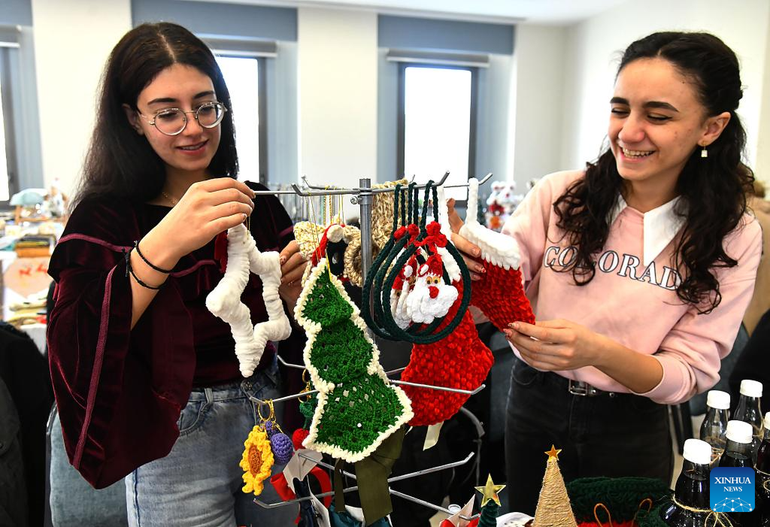 Sirios que visitan un mercado navideño en Damasco.