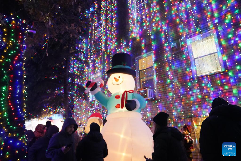 Personas observan coloridas decoraciones navideñas en el barrio de Dyker Heights, en Nueva York (Estados Unidos).