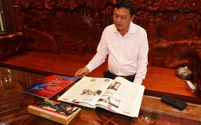 Al expresar su impresión, el lector Pham Van Hung destacó el contenido cada vez abundante y avanzado de la edición de Tet 2022 de Nhan Dan, junto a varias huellas de tecnología. (Fotografía: Xuan Son)