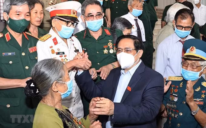 El primer ministro de Vietnam, Pham Minh Chinh, se encuentra con las personas con méritos revolucionarios. (Fotografía: VNA)