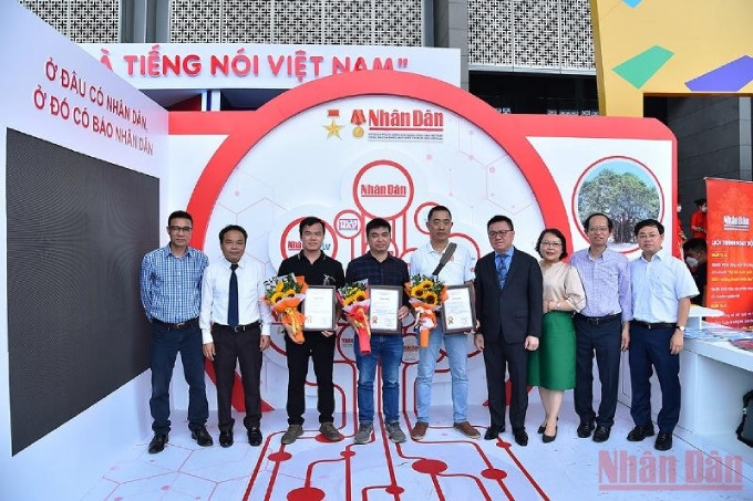 El jefe de redacción del periódico Nhan Dan, Le Quoc Minh, entrega premio a los ganadores. (Foto: Thuy Nguyen)