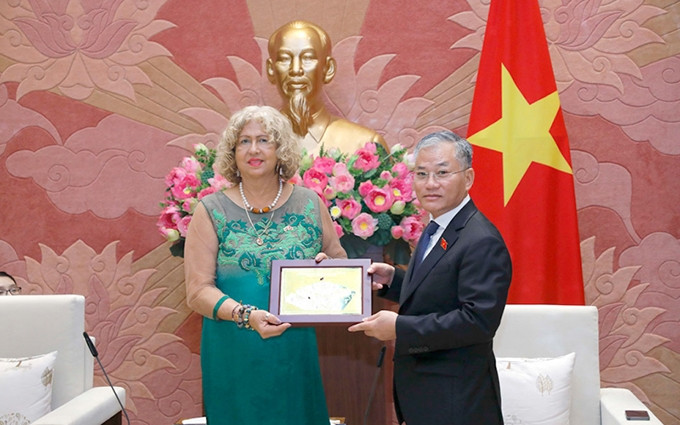 El vicepresidente del Comité de Relaciones Exteriores de la Asamblea Nacional de Vietnam, Don Tuan Phong, entrega recuerdo a la vicecanciller de Venezuela Capaya Rodríguez González. (Fotografía: daibieunhandan.vn)