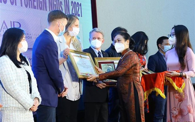La presidenta de la Unión de Organizaciones de Amistad de Vietnam, Nguyen Phuong Nga, entrega certificado de mérito a representantes de las ONG. (Fotografía: VNA)