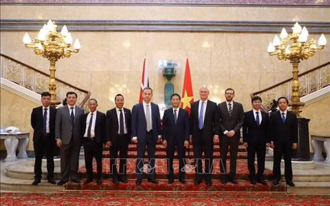 El miembro del Buró Político y jefe de la Comisión de Asuntos Económicos del Comité Central del Partido Comunista de Vietnam, Tran Tuan Anh, y representantes británicos. (Fotografía: VNA) 