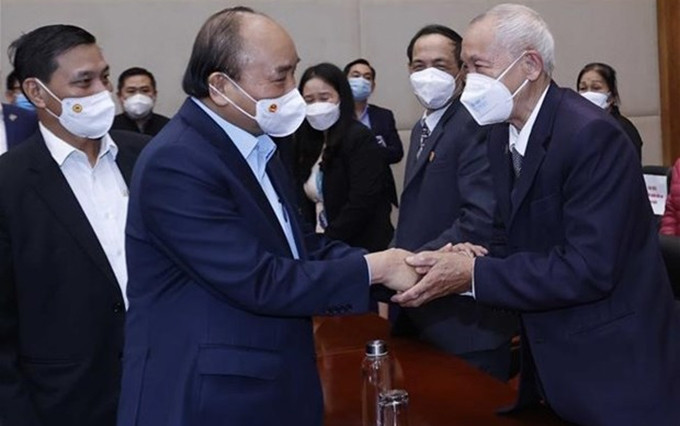 El presidente vietnamita, Nguyen Xuan Phuc, otorga obsequios a familias beneficiarias de las políticas sociales. (Fotografía: VNA)
