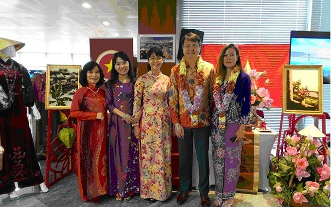 El director general de WIPO, Daren Tang, y su esposa (los dos primeros desde la derecha) en el stand de Vietnam. (Fotografía: VNA)