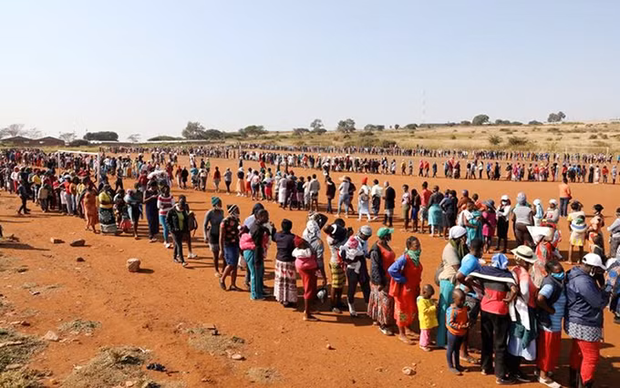 Personas hacen cola esperando su turno para recibir alimentos en Sudáfrica. (Fotografía: Reuters)