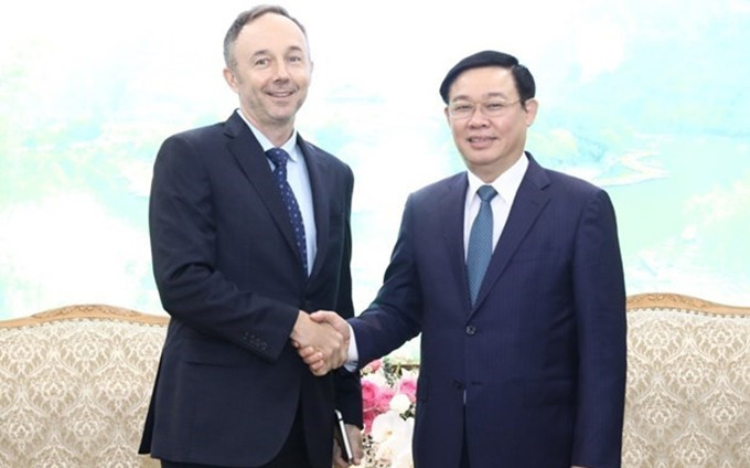 El viceprimer ministro Vuong Dinh Hue recibe al vicepresidente de Nike, Chris Helzer (Fotografía: VNA)