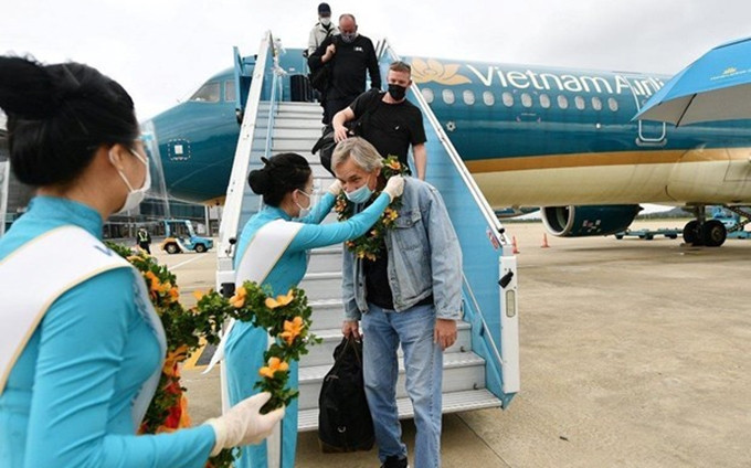 Pasajeros internacionales en un vuelo de Vietnam Airlines a Vietnam. (Fotografía: VNA)