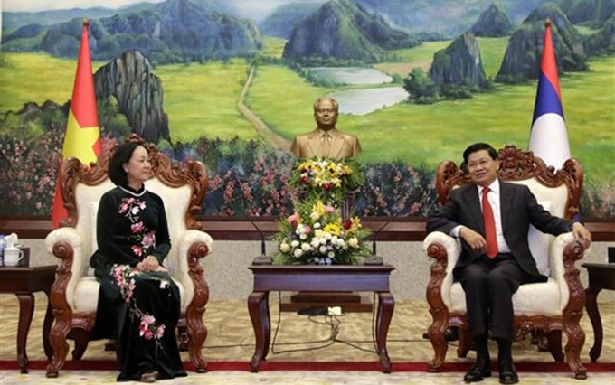 El secretario general del PPRL y presidente de Laos, Thongloun Sisoulith, recibe a la miembro del Buró Político y el Secretariado del Comité Central del PCV y jefa de su Comisión de Organización, Truong Thi Mai. (Fotografía: VNA)