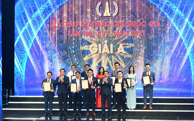El primer ministro Pham Minh Chinh y el jefe de la Comisión de Comunicación y Educación del CC del PCV, Nguyen Trong Nghia, entregan el premio A a los ganadores. (Fotografía: Thanh Dat) 