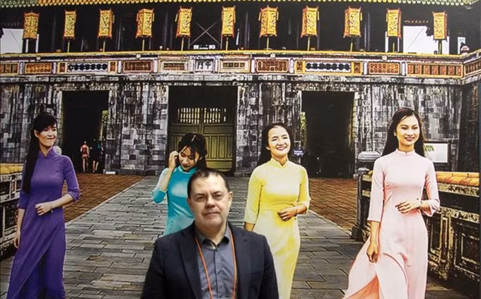 El experto ruso con el panel de las chicas vietnamitas que llevaban los sombreros cónico tradicional. (Fotografía: VNA)