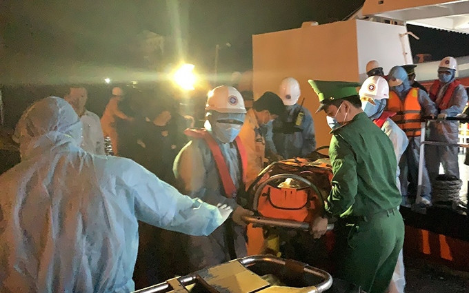 Llevan al tripulante herido a tierra firme. (Fotografía: Nhan Dan)